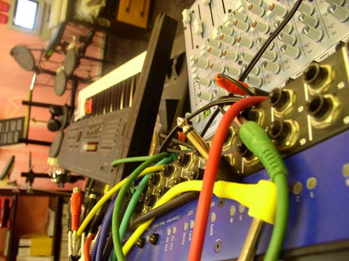 Verschiedene Kabel, Mischpult und Keyboard im Hintergrund